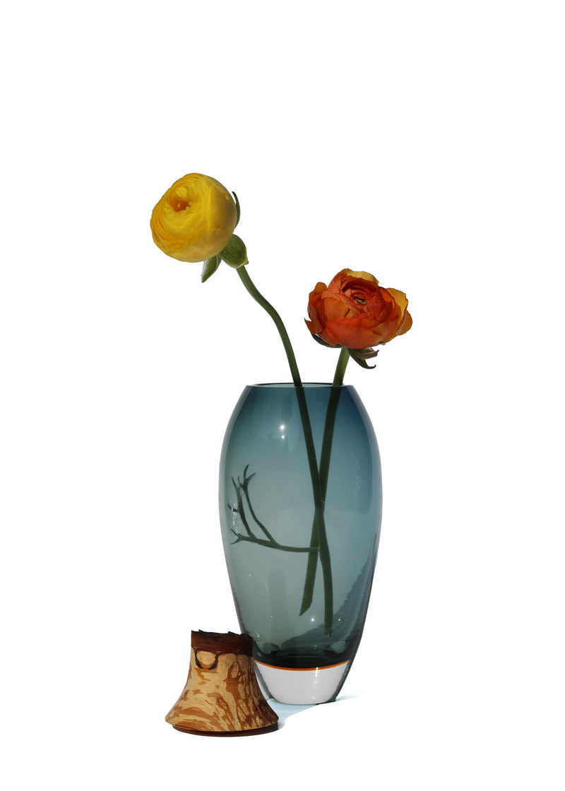 Matisse I Vase in Blue unstacked with a flower, showcasing its unique design and color contrast.