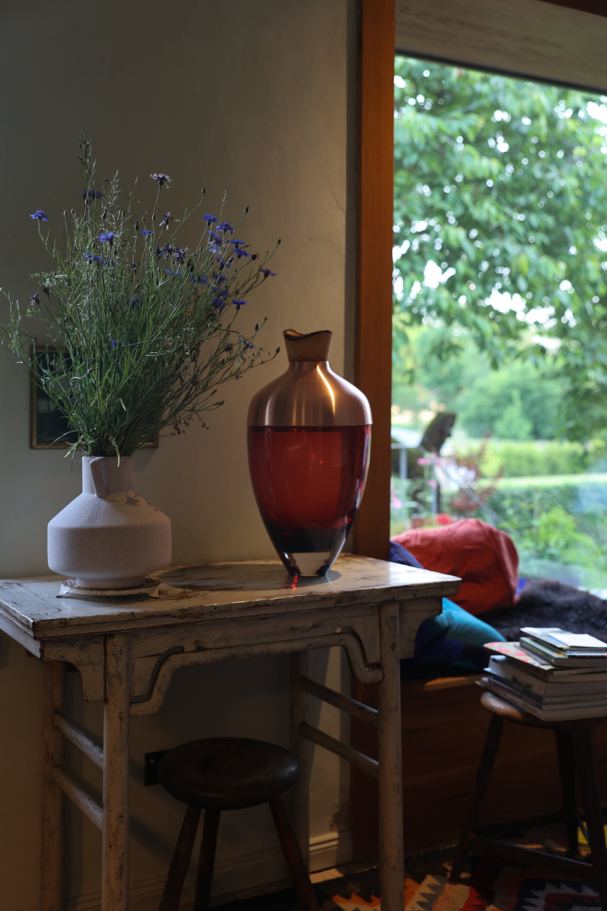 Nani Stacking Vessel in Red & Copper, offering a vibrant red color complemented by sleek copper accents, perfect for adding warmth and sophistication to any room.
